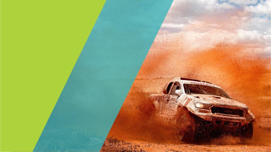 Un véhicule de course dans un désert, soulevant un nuage de poussière orange, pendant une course automobile, probablement un rallye.