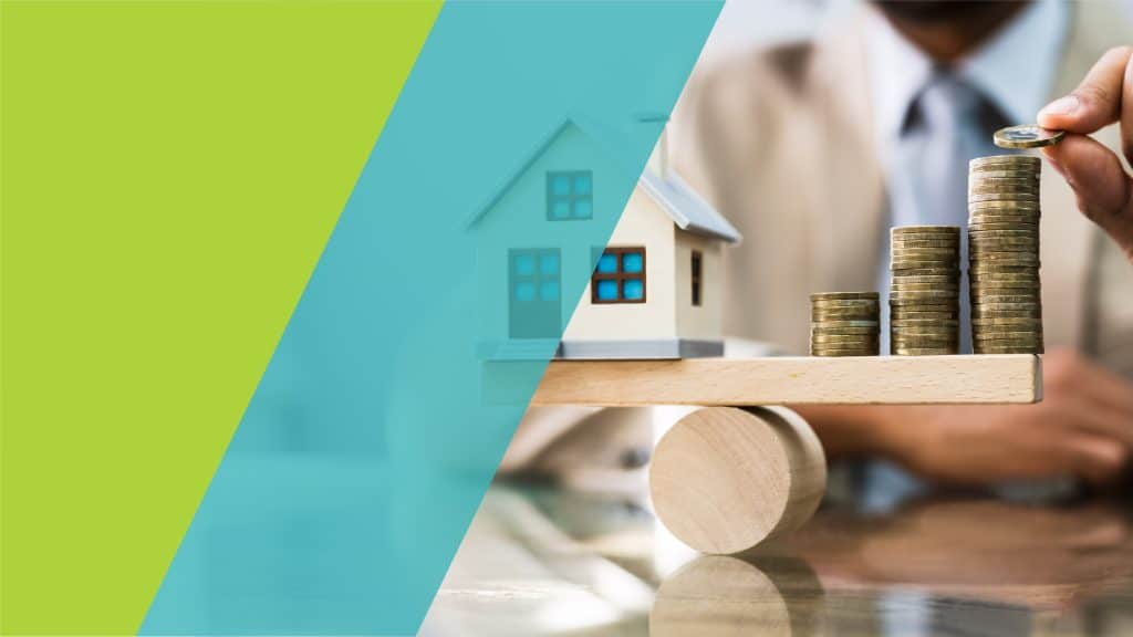 Maison en miniature sur une balance avec des piles de pièces de monnaie, symbolisant l'impact financier d'un crédit immobilier.