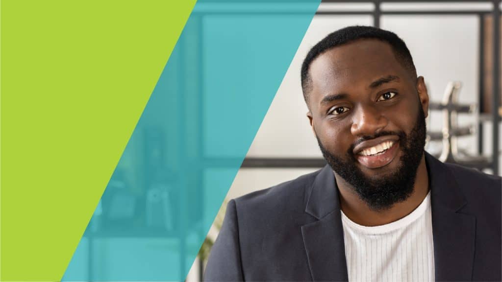 Un homme souriant en costume, prêt à relever des défis professionnels dans un environnement moderne.