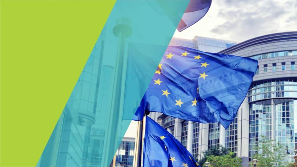 Drapeaux de l'Union européenne flottant devant un bâtiment moderne.