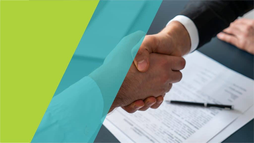 Deux personnes se serrent la main au-dessus d'un document signé, symbolisant un accord formel.