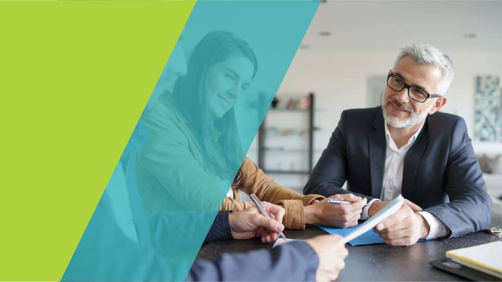 Des professionnels en réunion, discutant et signant des documents dans un environnement de travail moderne.