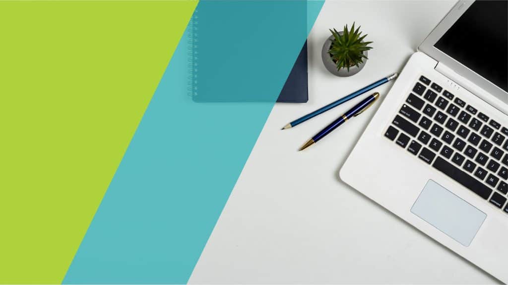 Un bureau avec un ordinateur portable, un carnet, des stylos et une plante, illustrant un espace de travail professionnel.