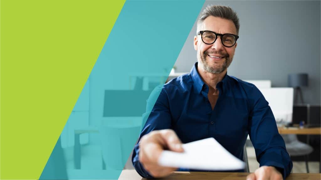 Un homme souriant tend un document à la caméra dans un bureau moderne, illustrant un acte de collaboration ou de transaction.